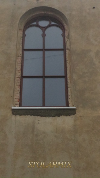 Przykład okna zabytkowego z pięknymi łukami i wykończeniem zewnętrznym w formie wałków. Całość szprosów okna jako konstrukcyjne.